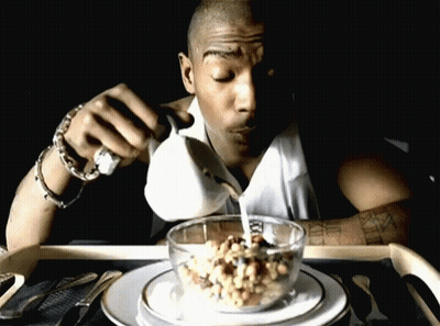 A Man Is Pouring Milk Into A Bowl Of Cereal With Roman Numerals On His Arm GIF