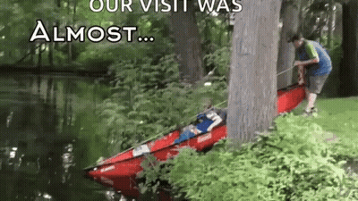 A Man Is Pulling A Kayak Out Of The Water . GIF