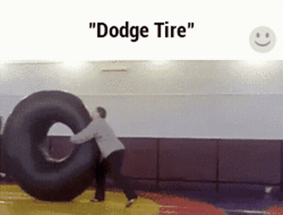 A Man Is Pushing A Tire That Says " Dodge Tire " On It GIF