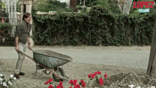 A Man Is Pushing A Wheelbarrow In A Garden With The Word Lopez On The Bottom GIF