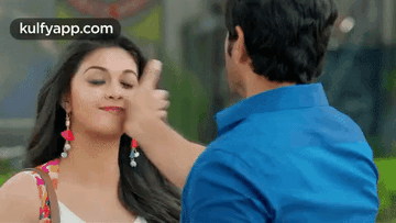 A Man Is Putting His Hand On A Woman 'S Forehead And Giving Her A Thumbs Up . GIF