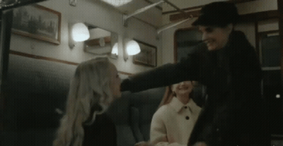 A Man Is Putting His Hand On A Woman 'S Head In A Train Car . GIF