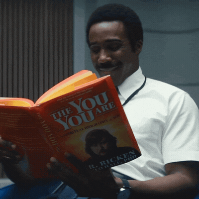 A Man Is Reading A Book Called The You Are By R. Ricken GIF