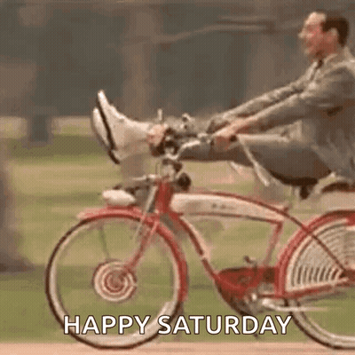 A Man Is Riding A Bicycle With His Feet Up And The Words `` Happy Saturday '' . GIF