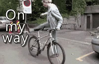 A Man Is Riding A Bike In A Parking Lot With The Words On My Way Behind Him GIF