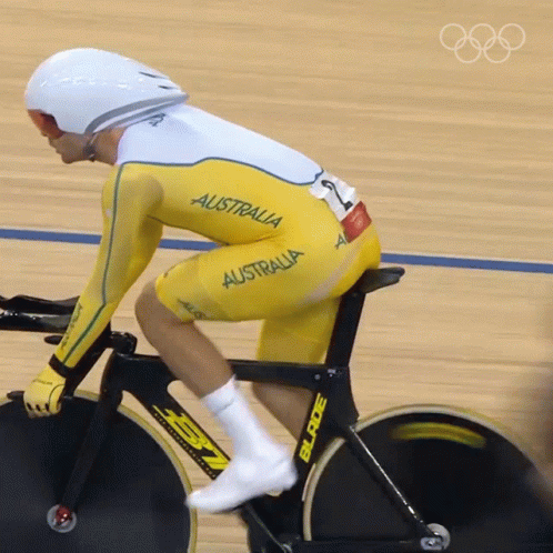 A Man Is Riding A Bike With The Word Australia On His Outfit GIF
