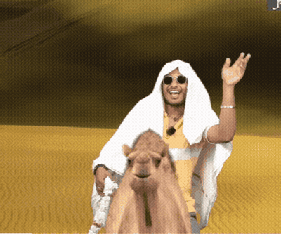 A Man Is Riding A Camel In The Desert GIF
