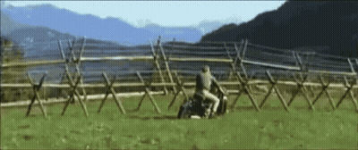 A Man Is Riding A Horse In A Field With Mountains In The Background GIF