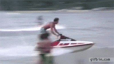 A Man Is Riding A Jet Ski On A Body Of Water GIF