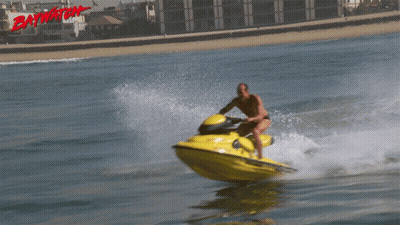 A Man Is Riding A Jet Ski With The Word Baywatch On The Bottom Right GIF