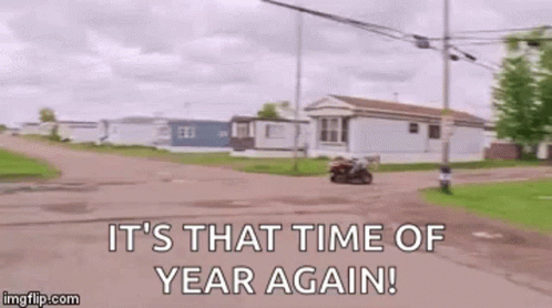 A Man Is Riding A Motorcycle Down A Dirt Road With The Words `` It 'S That Time Of Year Again '' . GIF