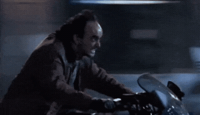 A Man Is Riding A Motorcycle On A Dark Street GIF