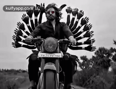 A Man Is Riding A Motorcycle With A Bunch Of Hands On The Back . GIF
