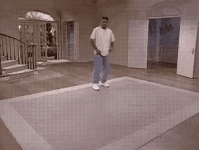 A Man Is Riding A Skateboard On A Rug In A Room . GIF