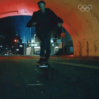 A Man Is Riding A Skateboard Through A Tunnel With The Olympic Rings On The Bottom GIF