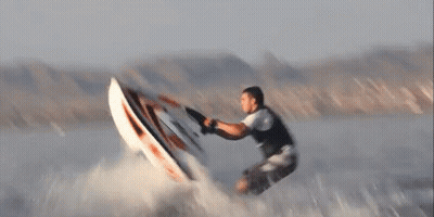 A Man Is Riding A Wave On A Surfboard That Says ' Jetski ' On It GIF