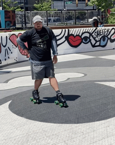 A Man Is Rollerblading In Front Of A Wall That Says Sheefs GIF