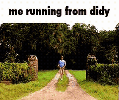 A Man Is Running Down A Dirt Road In A Field . GIF