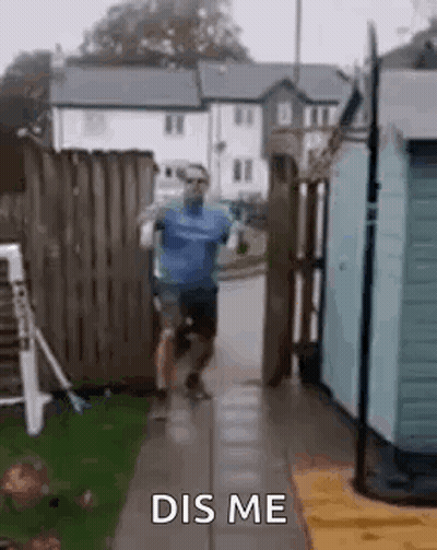 A Man Is Running Down A Sidewalk Next To A Fence . GIF