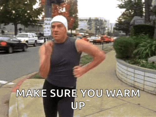 A Man Is Running Down A Sidewalk With The Words Make Sure You Warm Up Behind Him GIF