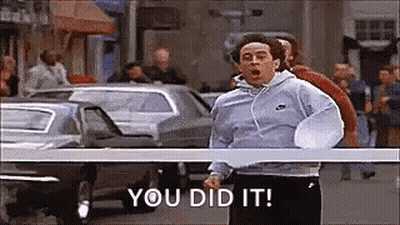 A Man Is Running Down A Street With The Words `` You Did It '' Written On The Screen . GIF