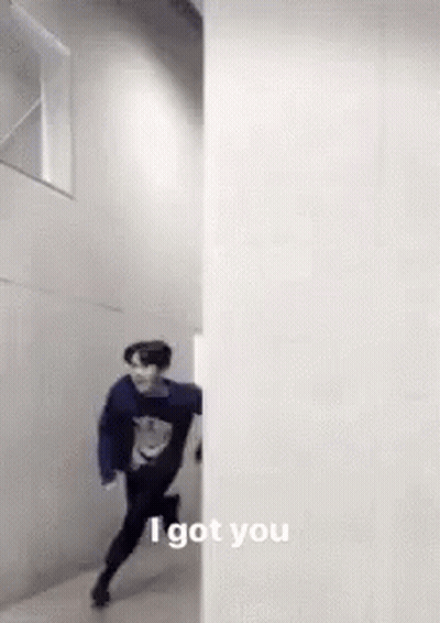 A Man Is Running Through A Hallway Next To A Wall And Says `` I Got You '' . GIF