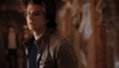 A Man Is Screaming In A Dark Room With His Arms Outstretched . GIF