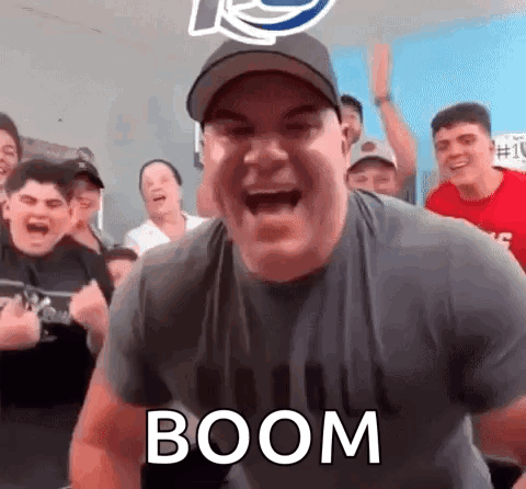 A Man Is Screaming In Front Of A Crowd Of People While Wearing A Hat And A Shirt That Says Boom . GIF