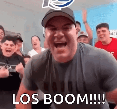 A Man Is Screaming In Front Of A Group Of People With The Words Los Boom Written On The Bottom . GIF