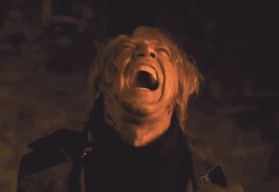 A Man Is Screaming In The Dark With His Mouth Open GIF