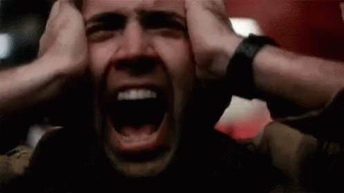 A Man Is Screaming With His Hands On His Head And His Mouth Open . GIF