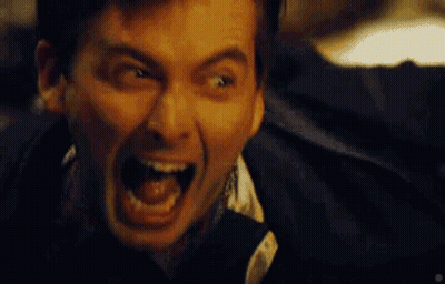 A Man Is Screaming With His Mouth Wide Open GIF