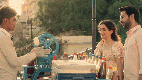 A Man Is Selling Ice Cream To A Woman GIF