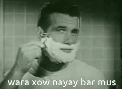 A Man Is Shaving His Face In A Black And White Photo With The Words Wara Xow Nayay Bar Mus On The Bottom . GIF
