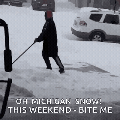A Man Is Shoveling Snow On A Sidewalk With A Sledge . GIF
