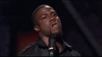 A Man Is Singing Into A Microphone And Making A Face . GIF