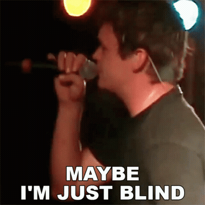a man is singing into a microphone and says maybe i 'm just blind