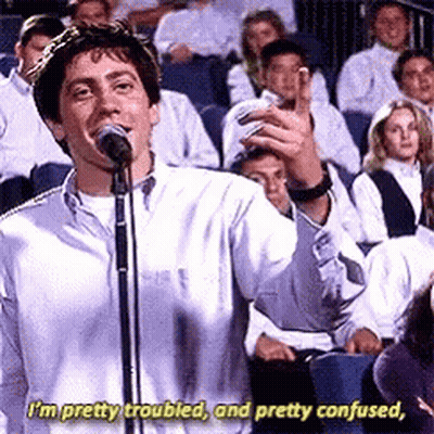 A Man Is Singing Into A Microphone In Front Of A Crowd And Says I 'M Pretty Troubled GIF