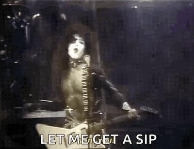 A Man Is Singing Into A Microphone While Playing A Guitar And Says Let Me Get A Sip GIF