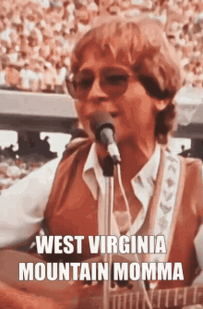 A Man Is Singing Into A Microphone While Playing A Guitar And Wearing Sunglasses . GIF