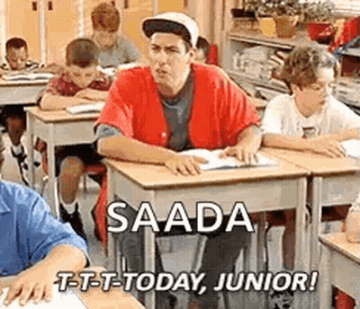 A Man Is Sitting At A Desk In A Classroom With Other Students . GIF