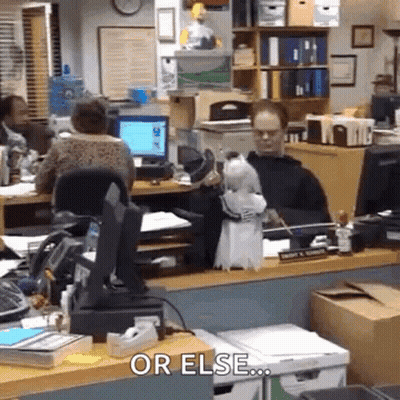 A Man Is Sitting At A Desk In An Office With A Parrot On His Desk . GIF