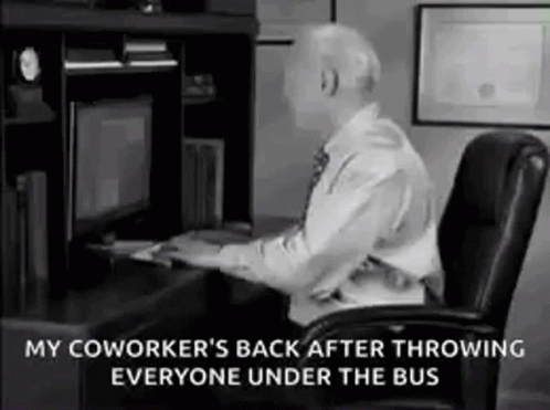 A Man Is Sitting At A Desk In Front Of A Computer And Throwing Someone Under The Bus . GIF