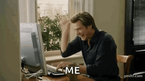 A Man Is Sitting At A Desk In Front Of A Computer With A Cup Of Coffee . GIF