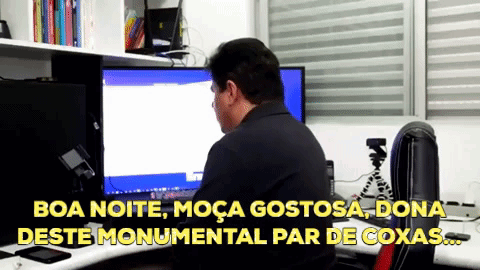 A Man Is Sitting At A Desk In Front Of A Computer With The Words Boa Noite Moça Gostosa Dona Deste Monumental GIF