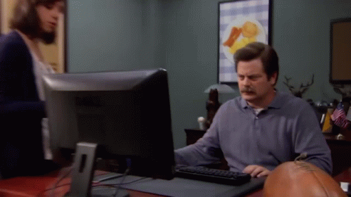 A Man Is Sitting At A Desk Using A Dell Computer GIF