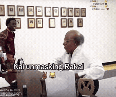 A Man Is Sitting At A Desk With A Laptop And The Words Kai Unmasking Rakai Written On The Screen GIF