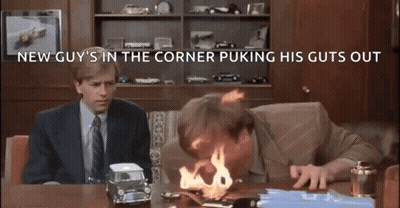 A Man Is Sitting At A Desk With A Toy Car On Fire . GIF