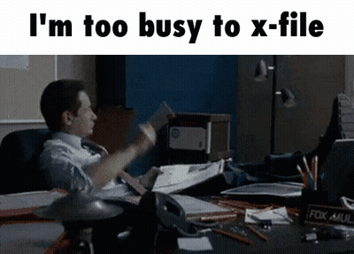 A Man Is Sitting At A Desk With His Feet Up And A Fox Mail Holder GIF