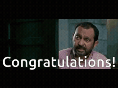 A Man Is Sitting At A Desk With The Words Congratulations Written On The Screen GIF